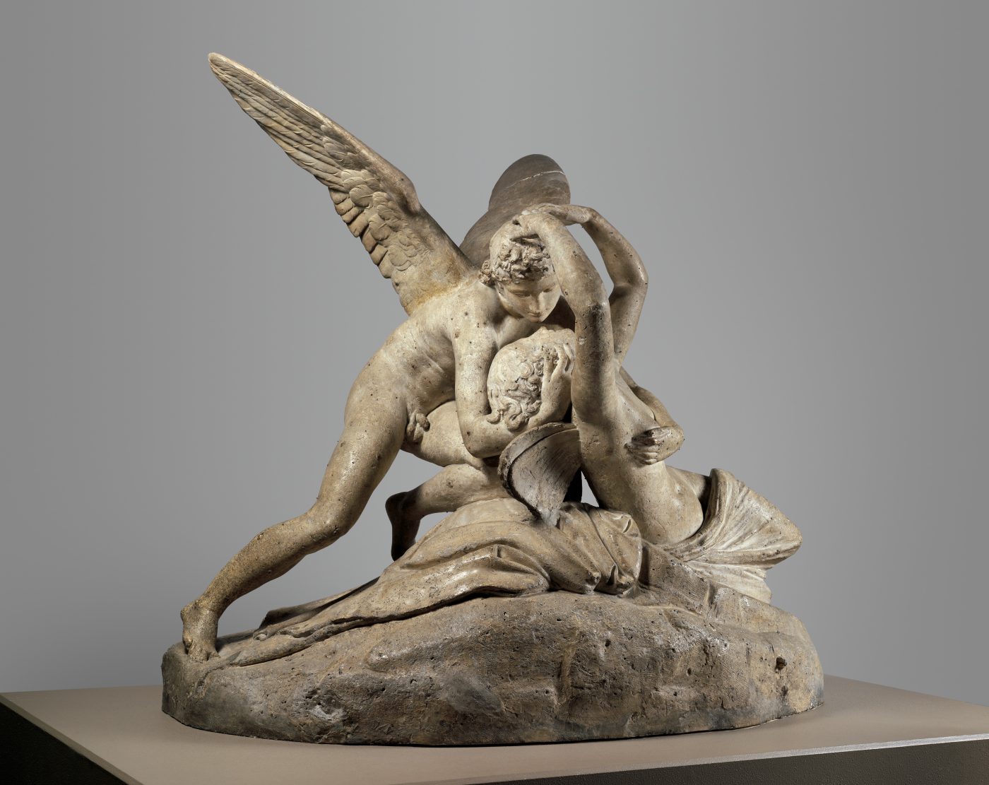 Canova's Cupid and Psyche: two figures in an embrace, Psyche reaching up to touch Cupid's face, carved so the surface reads as skin rather than stone.